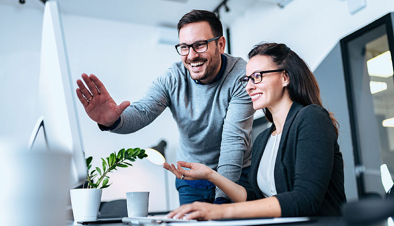 Ein Mann & eine Frau vor einem Computer