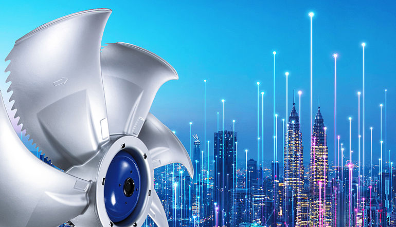 Innovation bei ZIEHL-ABEGG Grauer ZIEHL-ABEGG Ventilator mit blauem Motor vor einer Skyline bei Nacht