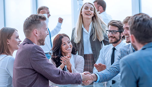Mission Zukunft Ein Team beglückwünscht applaudierend eine Person & einer schüttelt die Hand