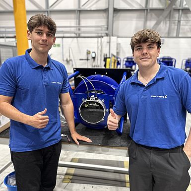 Two men standing in front of a ZIEHL-ABEGG product showing thumbs up