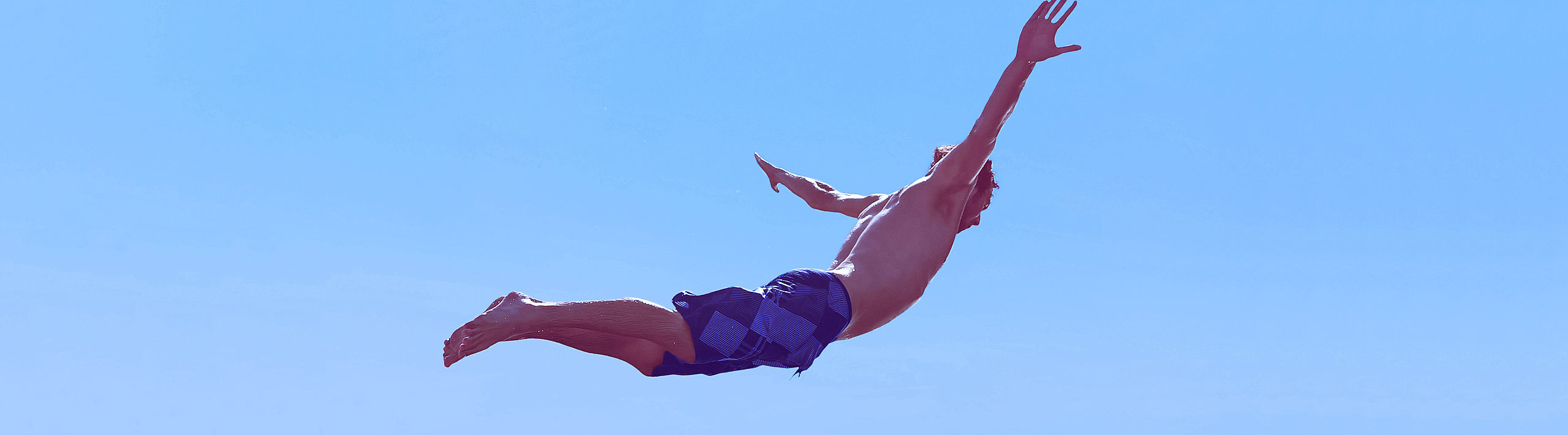 Person, die in der Luft fliegt beim Sprung ins Wasser